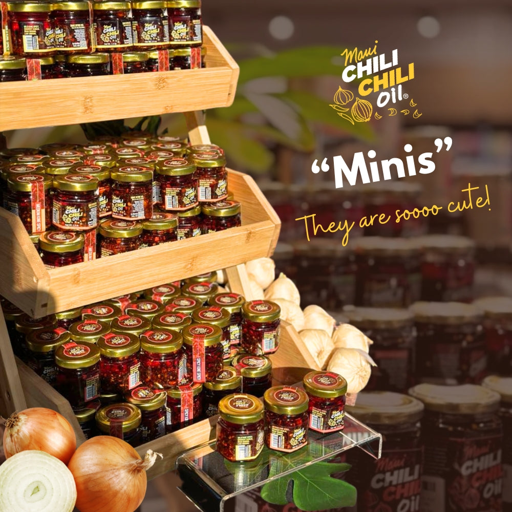 Display of small jars with 'Maui Chili Chili Oil' branding on a wooden shelf.